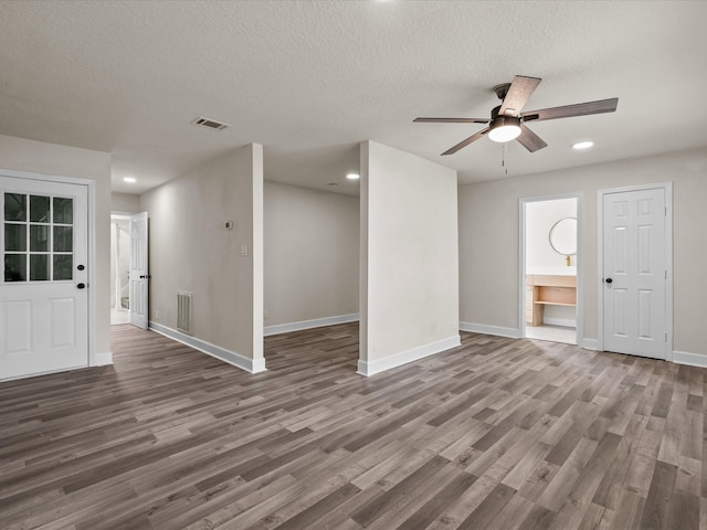 unfurnished living room with a textured ceiling, ceiling fan, and dark hardwood / wood-style floors