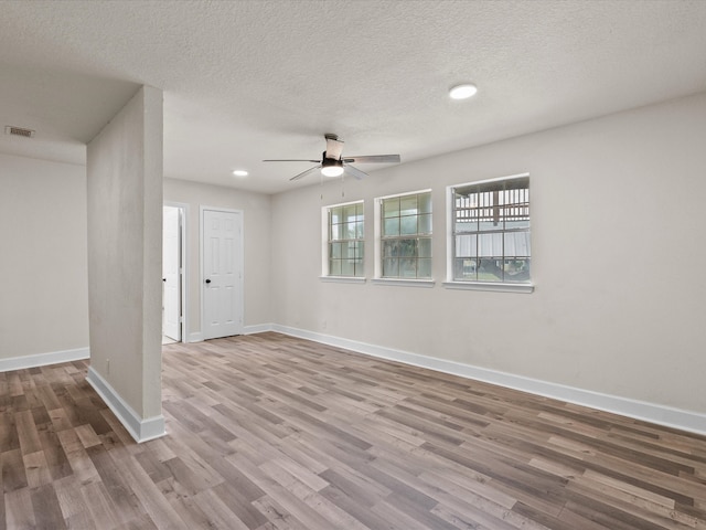 empty room featuring ceiling fan, wood-type flooring, and a textured ceiling