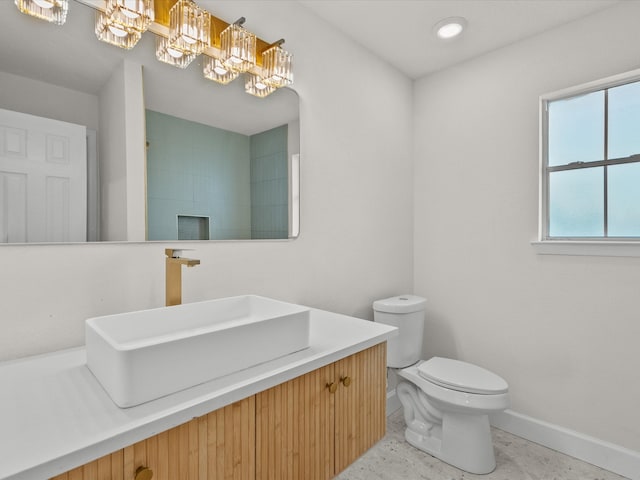 bathroom with tile patterned flooring, vanity, toilet, and an inviting chandelier