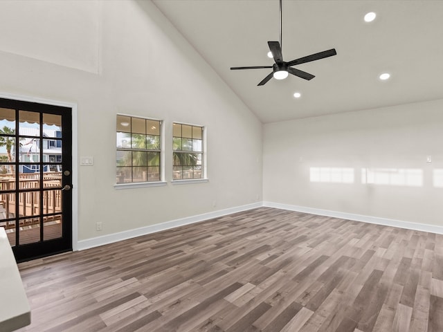 spare room with wood-type flooring, high vaulted ceiling, and ceiling fan