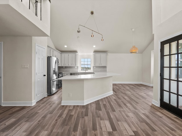 kitchen featuring hardwood / wood-style floors, a center island, and stainless steel fridge