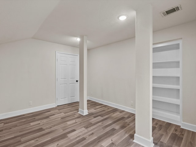 basement featuring hardwood / wood-style flooring and built in features