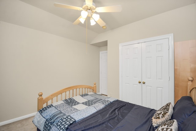 carpeted bedroom featuring a closet, vaulted ceiling, and ceiling fan