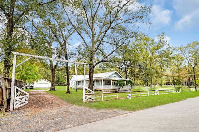 view of front facade featuring an outbuilding, a porch, and a garage