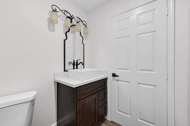 bathroom with hardwood / wood-style floors, vanity, and toilet