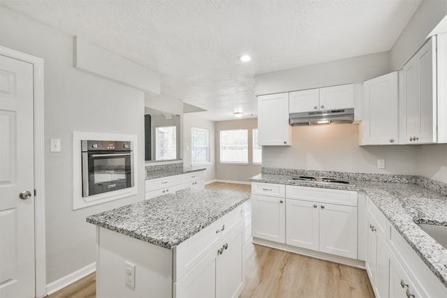 kitchen featuring white cabinets, white gas cooktop, light hardwood / wood-style flooring, and stainless steel oven