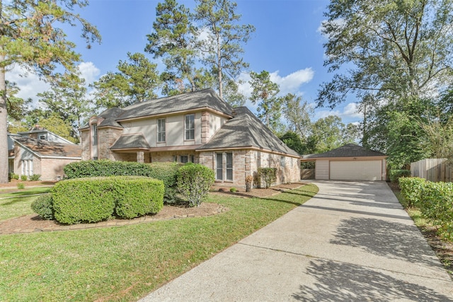 view of front facade with a front yard, a garage, and an outdoor structure