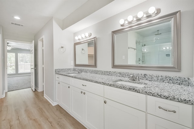 bathroom with wood-type flooring, vanity, a shower with door, and ceiling fan