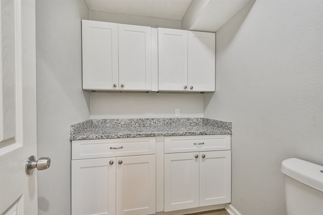 interior space featuring vanity and toilet