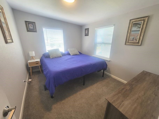 bedroom featuring lofted ceiling and dark colored carpet