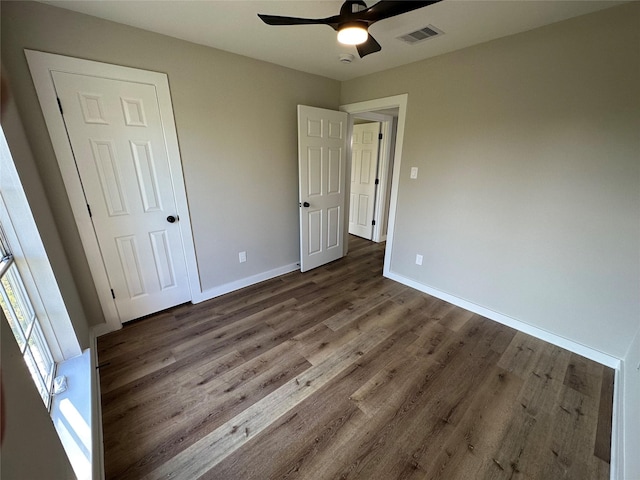 unfurnished bedroom featuring ceiling fan and dark wood-type flooring