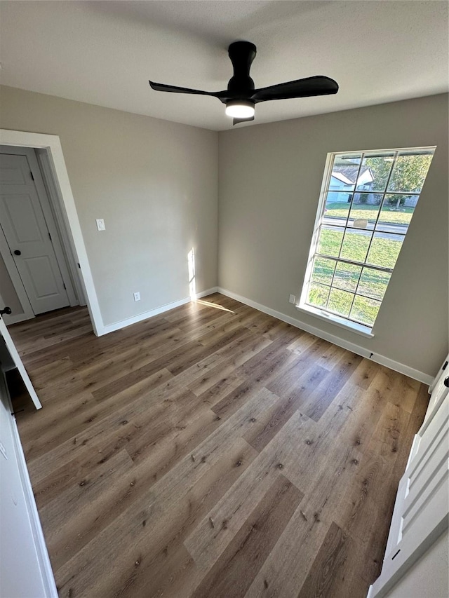 empty room with ceiling fan and hardwood / wood-style floors