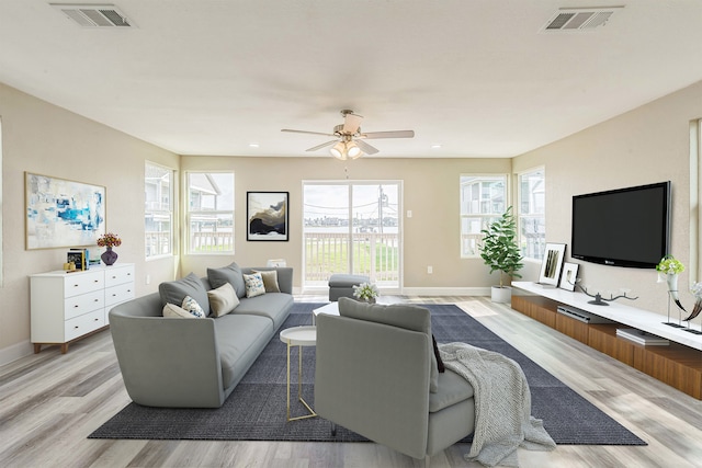 living room with light hardwood / wood-style flooring, plenty of natural light, and ceiling fan