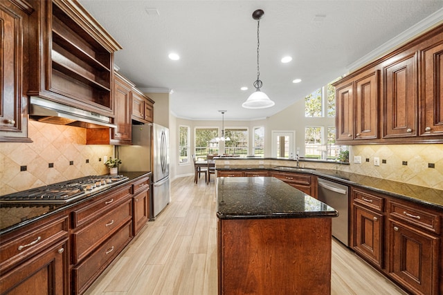 kitchen with premium range hood, dark stone countertops, appliances with stainless steel finishes, decorative light fixtures, and a kitchen island