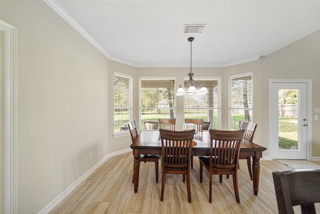 dining room featuring crown molding, light hardwood / wood-style floors, and an inviting chandelier