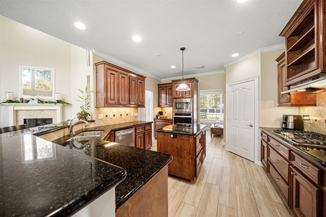 kitchen with a center island, sink, hanging light fixtures, stainless steel appliances, and kitchen peninsula