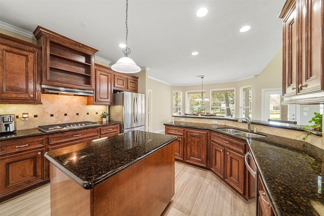 kitchen featuring sink, a center island, dark stone countertops, decorative light fixtures, and appliances with stainless steel finishes