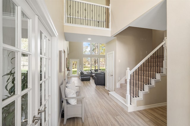 entrance foyer featuring a high ceiling, light hardwood / wood-style floors, and french doors