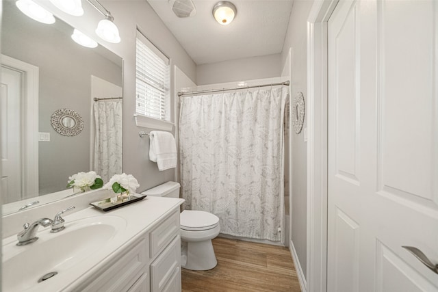 bathroom featuring toilet, vanity, a textured ceiling, and hardwood / wood-style flooring