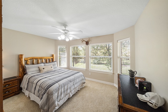 carpeted bedroom featuring ceiling fan, a textured ceiling, and multiple windows