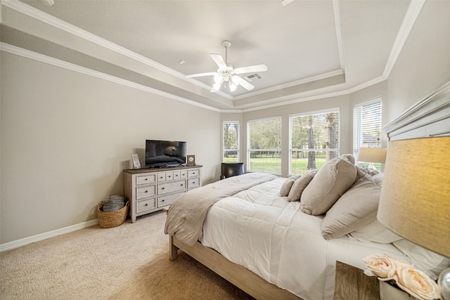 carpeted bedroom with a raised ceiling, ceiling fan, and ornamental molding