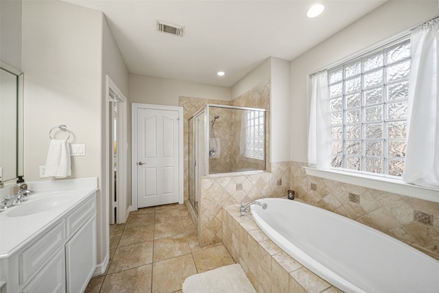 bathroom featuring tile patterned flooring, vanity, and plus walk in shower