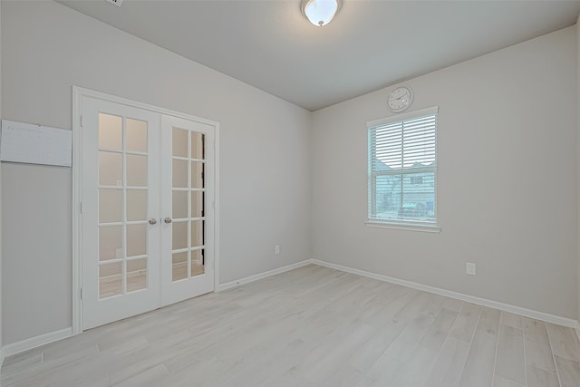 empty room with french doors and light wood-type flooring