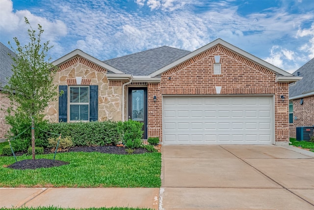 view of front of property with a front lawn, a garage, and central AC