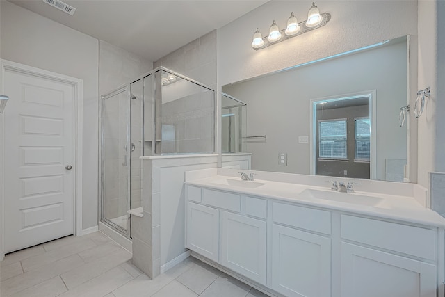 bathroom featuring tile patterned flooring, vanity, and walk in shower