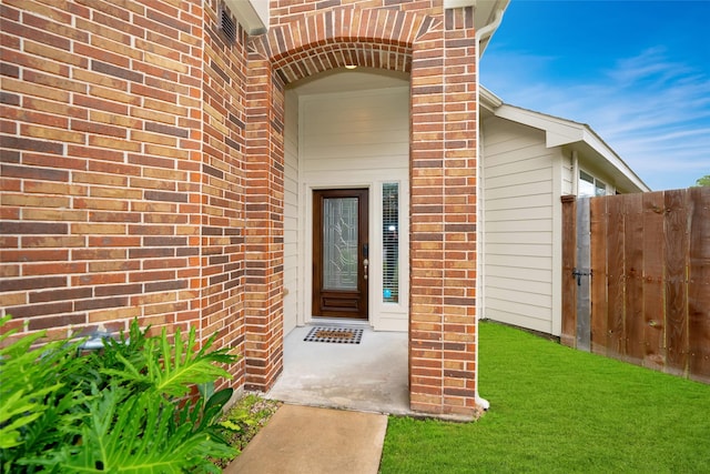 view of exterior entry with a lawn