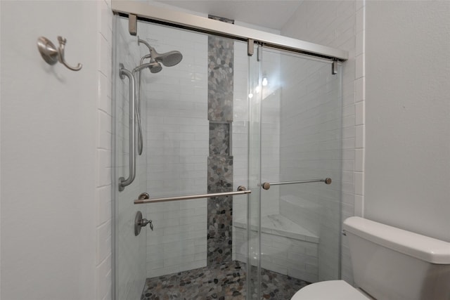 bathroom featuring toilet and an enclosed shower