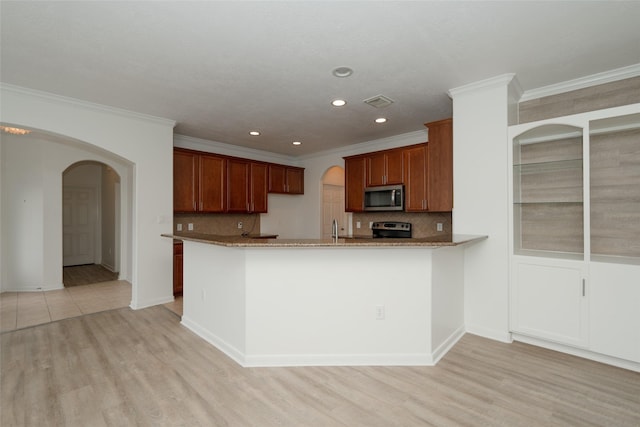 kitchen with decorative backsplash, kitchen peninsula, stainless steel appliances, and light hardwood / wood-style flooring