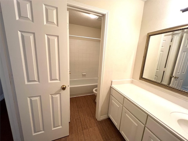 full bathroom with vanity, toilet, wood-type flooring, and tiled shower / bath