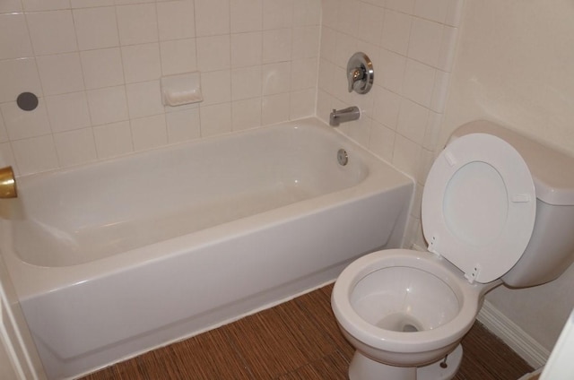 bathroom with tiled shower / bath combo and toilet