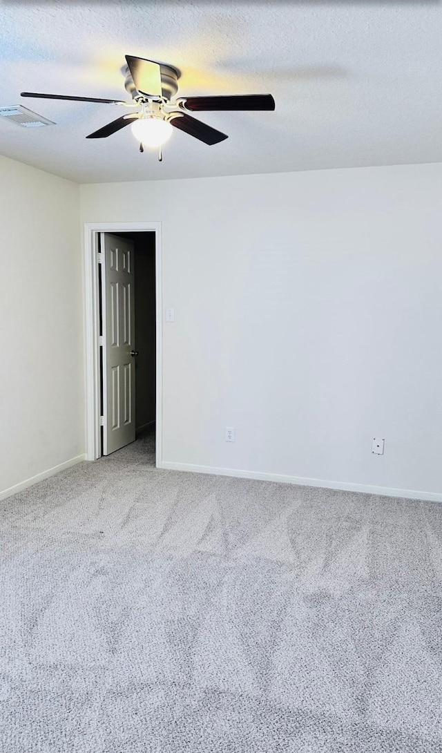 empty room featuring a textured ceiling, carpet floors, and ceiling fan