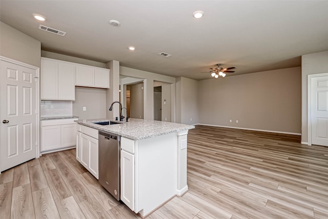 kitchen with white cabinets, sink, light hardwood / wood-style flooring, dishwasher, and an island with sink