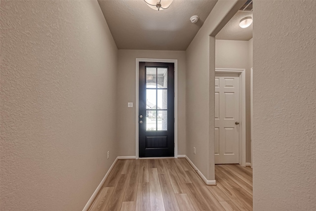 entryway featuring a textured ceiling and light wood-type flooring