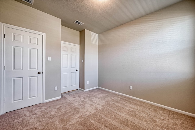 unfurnished bedroom featuring carpet and a textured ceiling