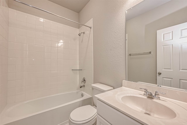 full bathroom featuring vanity, tiled shower / bath, and toilet