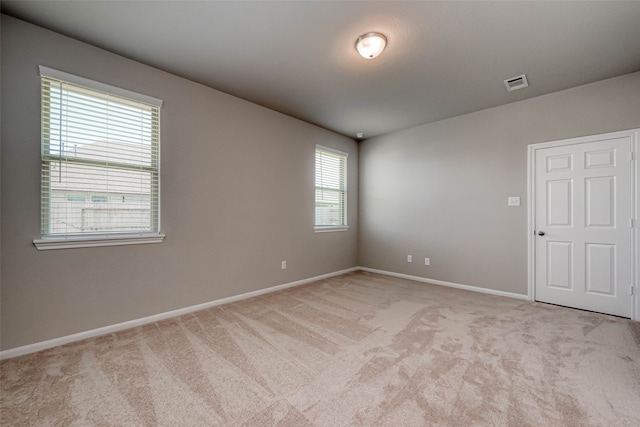 unfurnished room featuring light carpet