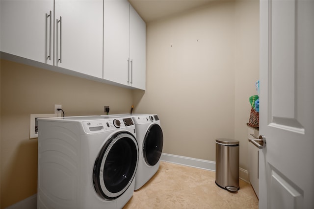 washroom featuring washer and dryer and cabinets