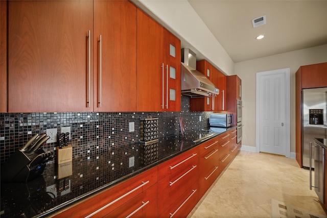 kitchen with wall chimney exhaust hood, stainless steel appliances, and tasteful backsplash