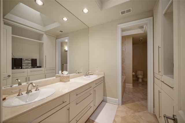 bathroom with vanity, toilet, and a tub to relax in