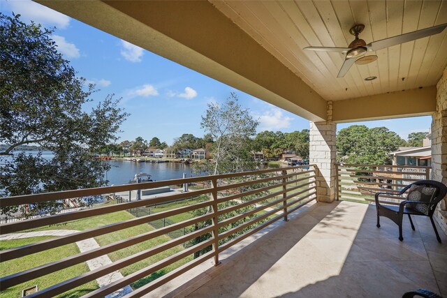 balcony with ceiling fan and a water view