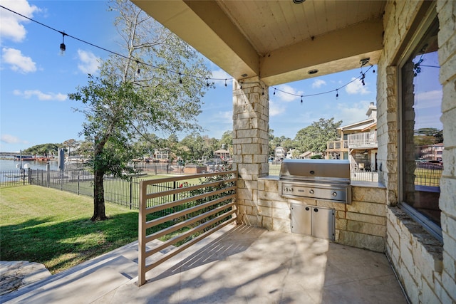 view of patio / terrace with an outdoor kitchen, a water view, and grilling area