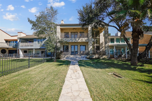 view of front of property featuring a front yard and french doors