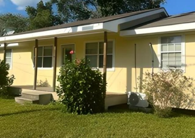 rear view of property featuring a lawn