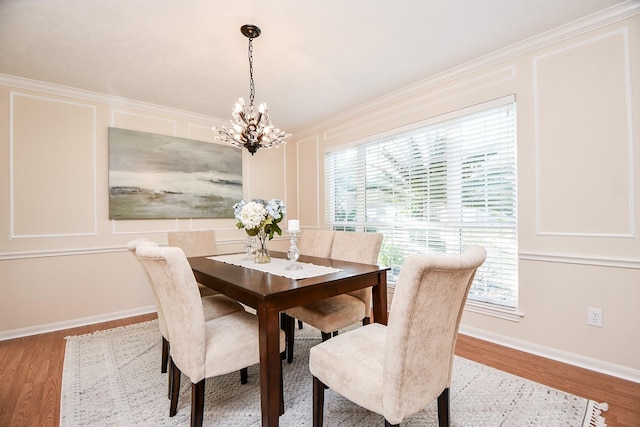 dining room with crown molding, wood-type flooring, and a notable chandelier