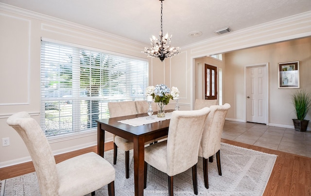 dining space featuring a chandelier, a textured ceiling, hardwood / wood-style flooring, and crown molding