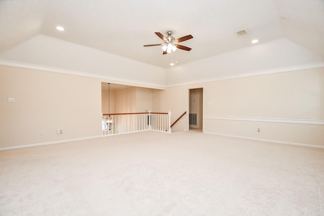 carpeted empty room with ceiling fan, crown molding, and a tray ceiling